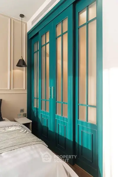 Stylish bedroom with elegant teal sliding doors and modern lighting