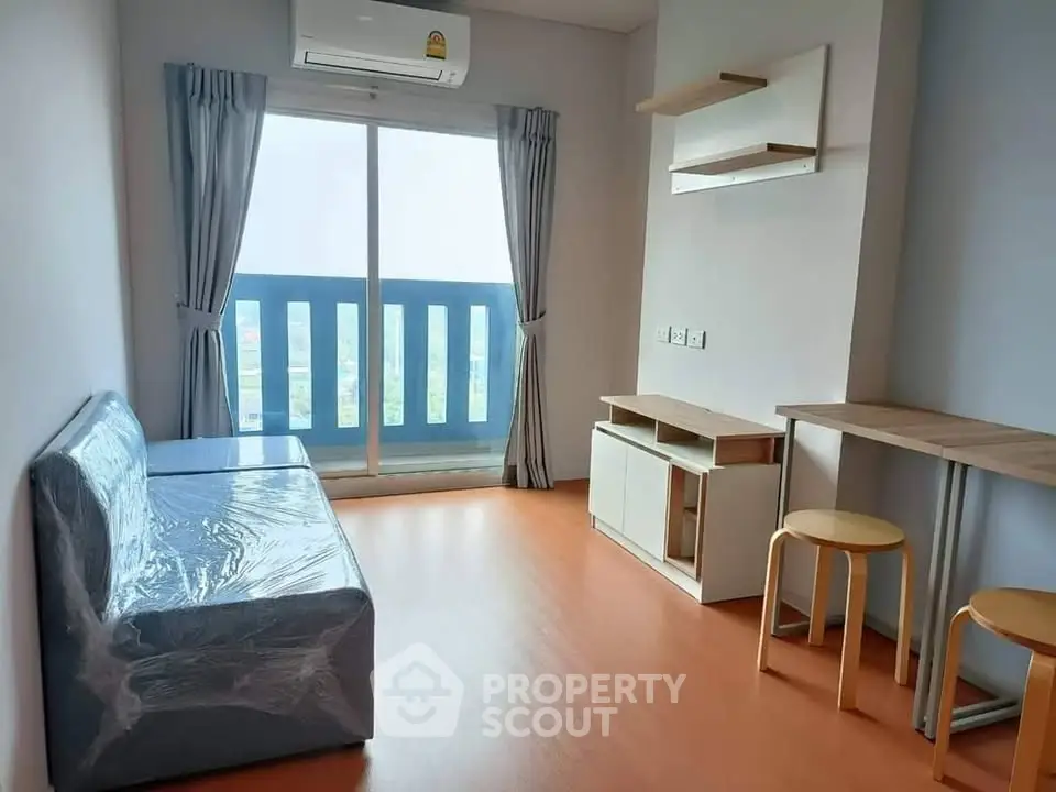 Modern living room with balcony view and minimalist furniture in a bright apartment.