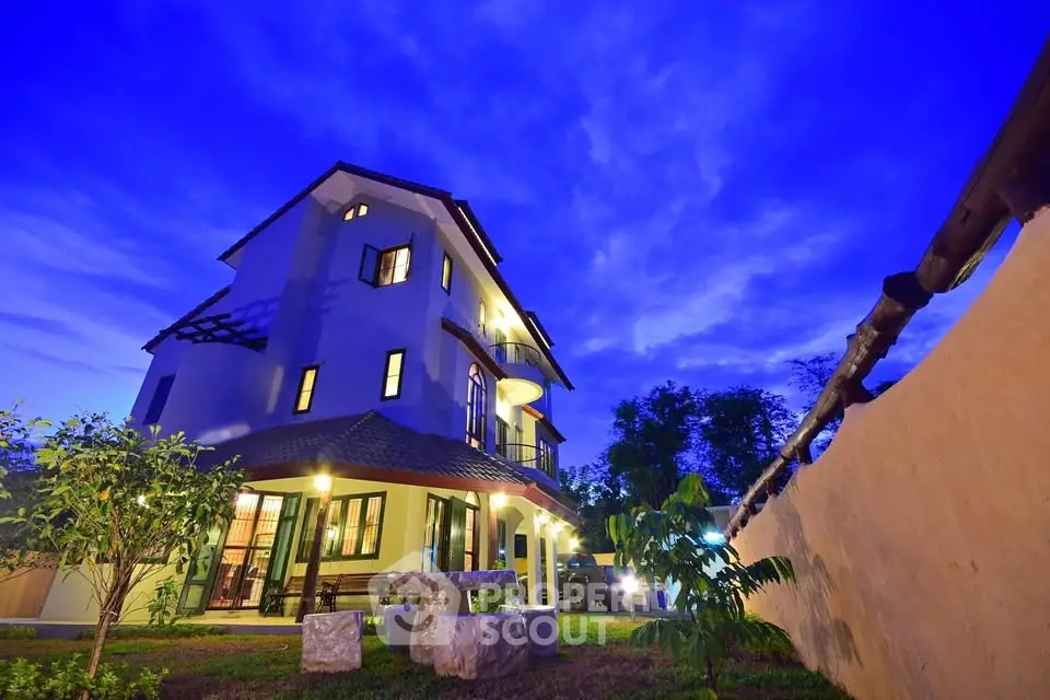 Stunning evening view of a modern multi-story house with lush garden.