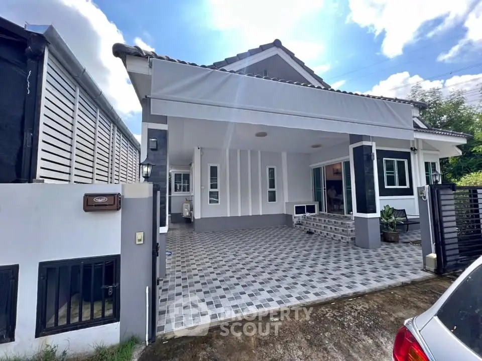 Charming single-story house with tiled driveway and modern facade under a bright blue sky.