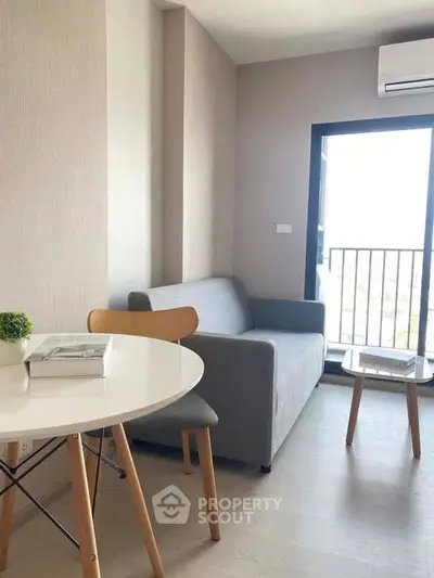 Modern living room with cozy sofa, stylish table, and balcony view in a bright apartment.