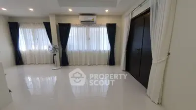 Spacious living room with large windows and elegant curtains