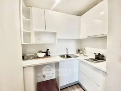 Modern white kitchen with sleek cabinets and compact design