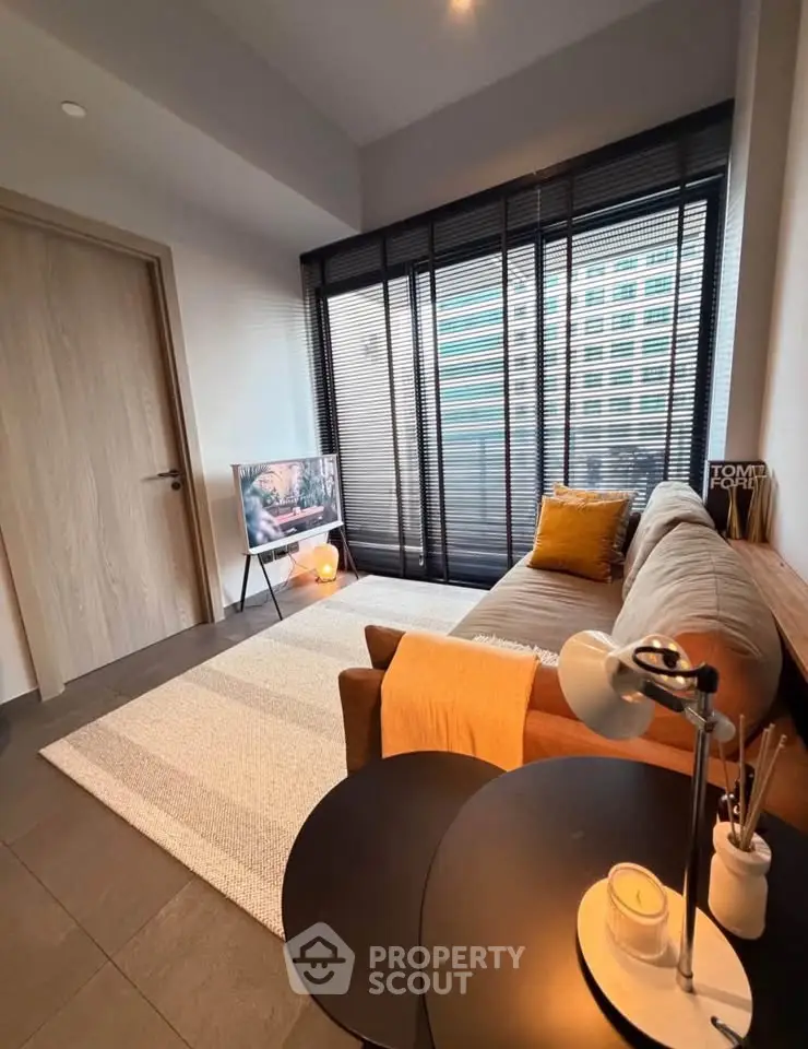 Modern living room with stylish decor and large window, featuring a cozy sofa and contemporary lighting.