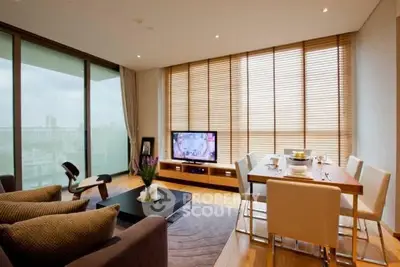 Modern living room with floor-to-ceiling windows and stylish dining area.