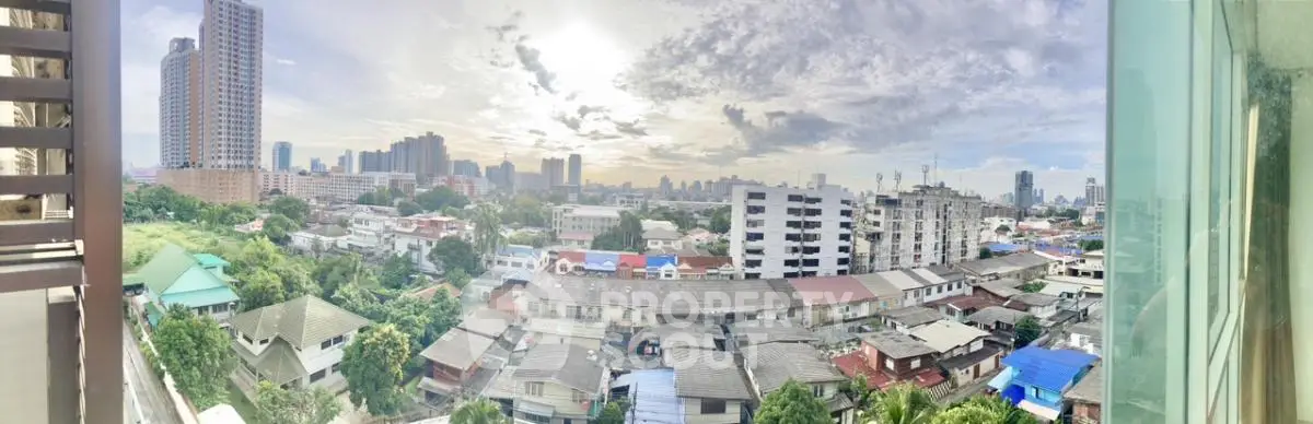 Panoramic cityscape view from a high-rise balcony showcasing urban skyline and residential area.