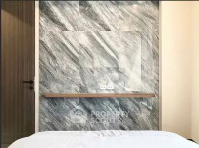 Modern bedroom with elegant marble accent wall and minimalist design