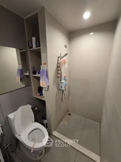Modern bathroom with shower and toilet, sleek design and neutral tones.