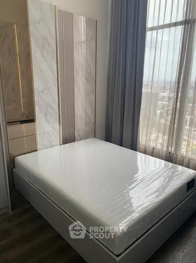 Modern bedroom with large window and stylish decor in high-rise apartment