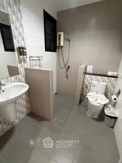 Modern bathroom with sleek tiles and walk-in shower in contemporary home.