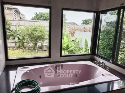 Luxurious bathroom with a large bathtub and garden view, perfect for relaxation.