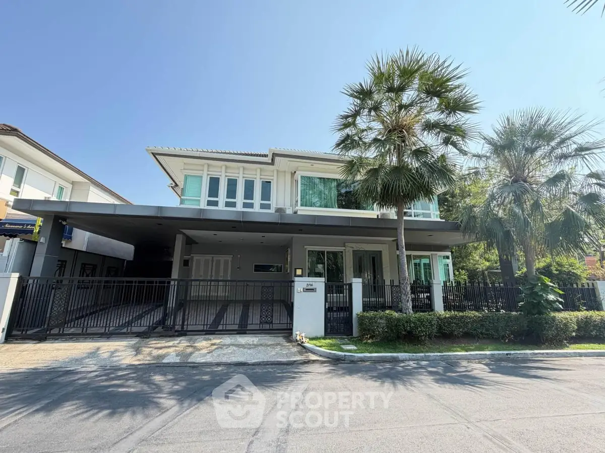 Luxurious modern house with spacious driveway and lush palm trees in a serene neighborhood.