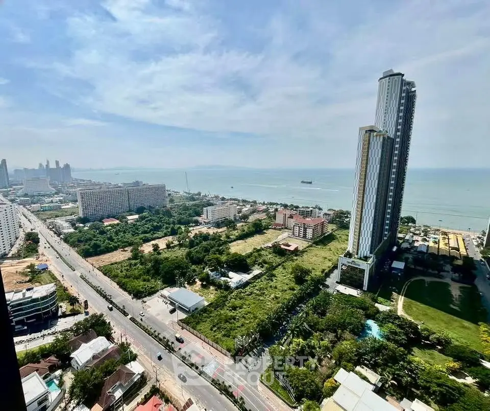 Stunning high-rise coastal view with modern skyscraper and lush greenery, perfect for luxury living.