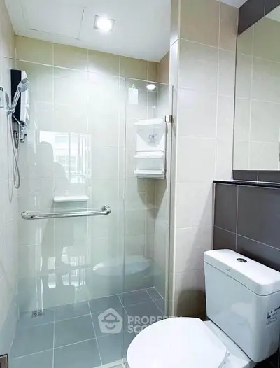 Modern bathroom with glass shower enclosure and sleek fixtures in a contemporary apartment.