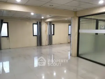Spacious commercial office space with large windows and tiled flooring