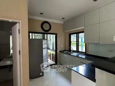 Modern kitchen with sleek cabinetry and large windows for natural light