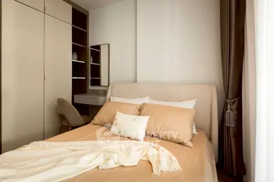 Cozy bedroom with elegant decor and ample natural light, featuring a comfortable bed and stylish furnishings.