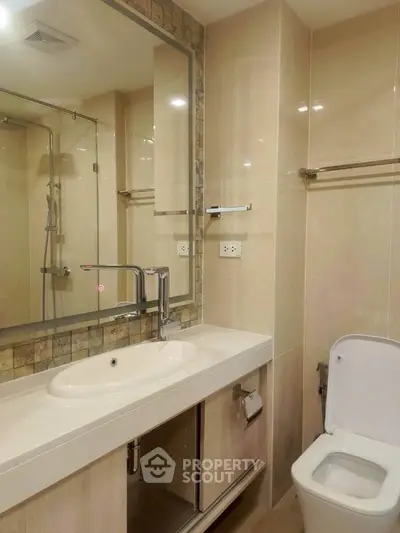 Modern bathroom with sleek fixtures and large mirror in a contemporary home.