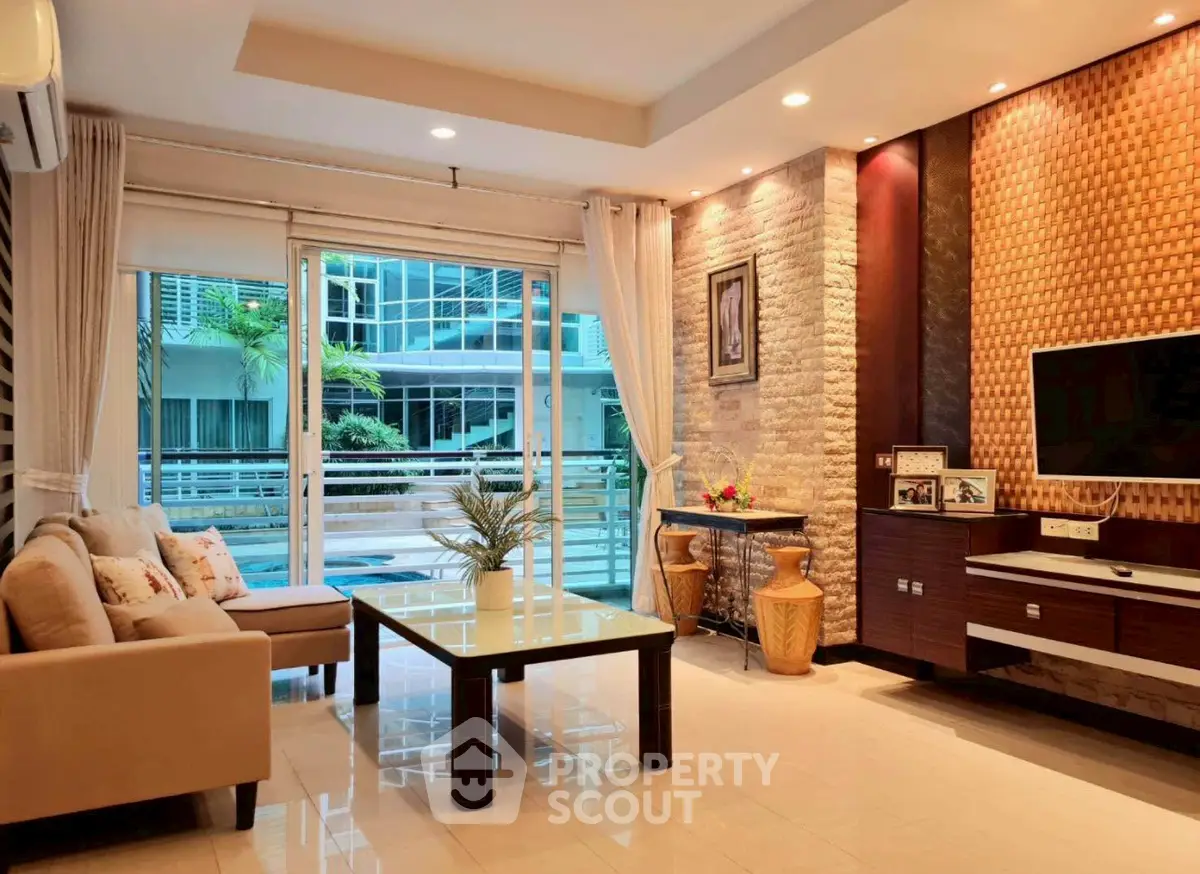 Luxurious living room with modern decor and pool view, perfect for relaxation and entertainment.