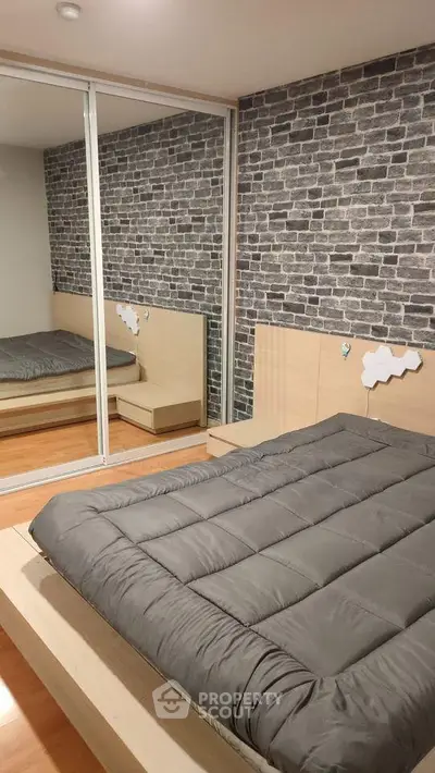 Modern bedroom with mirrored closet and stylish brick accent wall