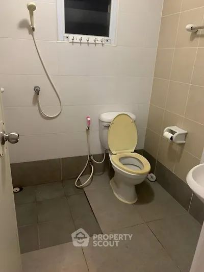 Compact bathroom with shower and toilet in neutral tones