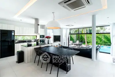 Luxurious open-plan kitchen and living room with pool view, modern appliances, and stylish decor.