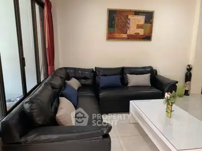 Modern living room with black leather sofa and stylish decor