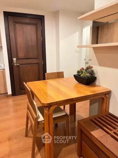 Cozy dining area with wooden table and chairs, perfect for intimate meals in a modern apartment.