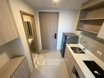 Modern kitchen with sleek cabinetry and compact appliances in a contemporary apartment.