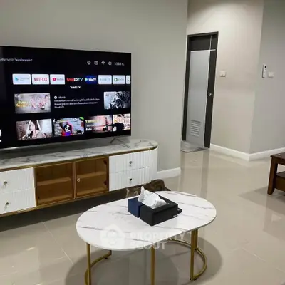 Modern living room with sleek TV setup and stylish coffee table in a contemporary home.