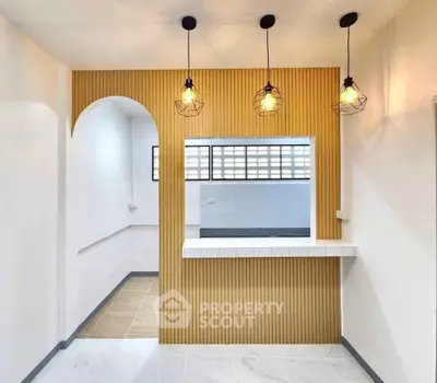 Modern kitchen with open layout and stylish lighting fixtures.