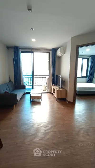 Modern living room with wooden flooring and balcony view in a stylish apartment