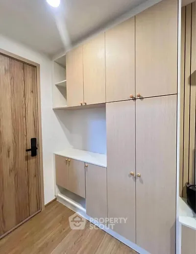 Modern storage cabinets in a stylish apartment entryway with wooden flooring.