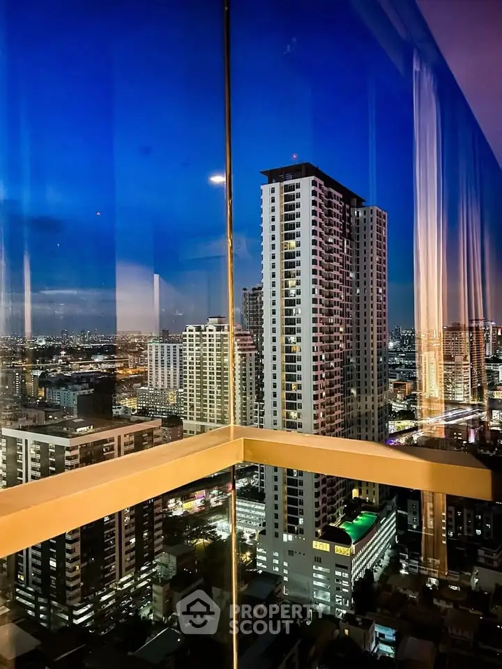 Stunning cityscape view from a high-rise building window at dusk, showcasing urban skyline and vibrant city lights.