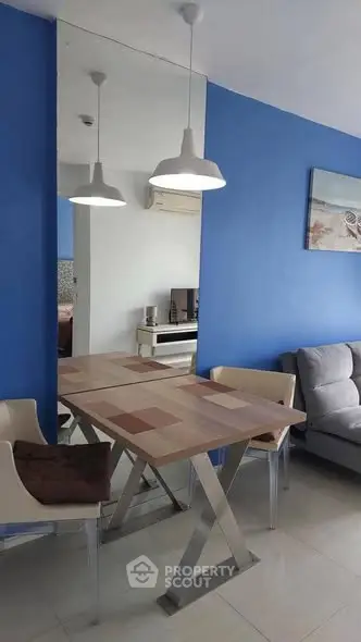 Modern living room with stylish dining table and blue accent wall