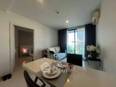 Modern living room with dining area and balcony view in a stylish apartment.