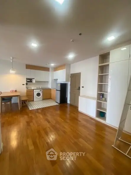 Spacious kitchen with wooden flooring and modern appliances in open layout