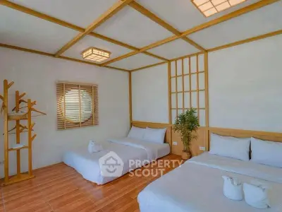 Spacious bedroom with two beds and modern decor, perfect for relaxation.