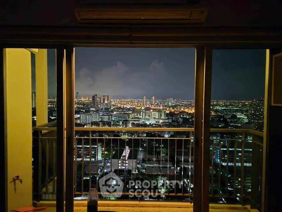 Stunning cityscape view from high-rise balcony at night, showcasing vibrant urban lights.