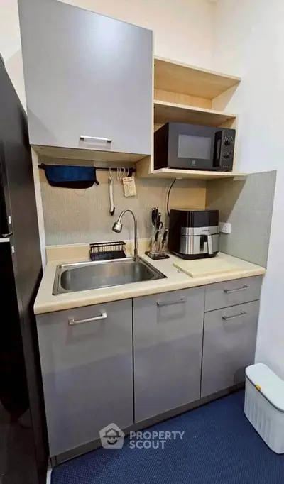 Compact kitchen with modern appliances and sleek cabinetry, perfect for efficient cooking in small spaces.