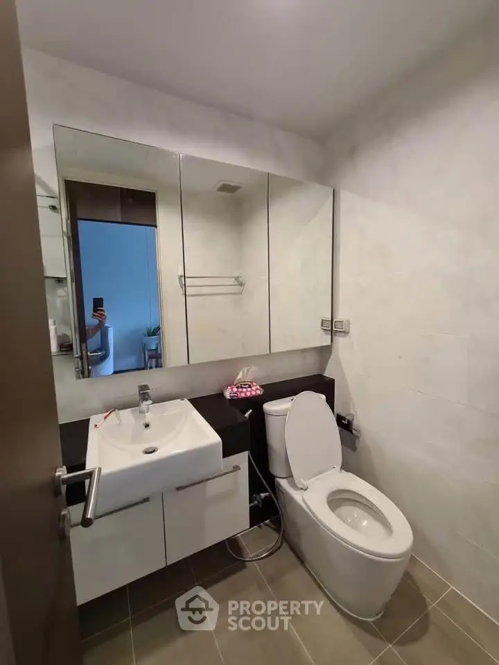 Modern bathroom with sleek fixtures and large mirror in a contemporary home.
