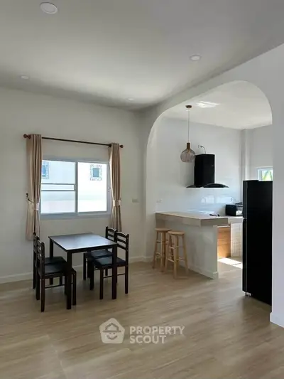Modern open-plan kitchen and dining area with natural light and wooden flooring.