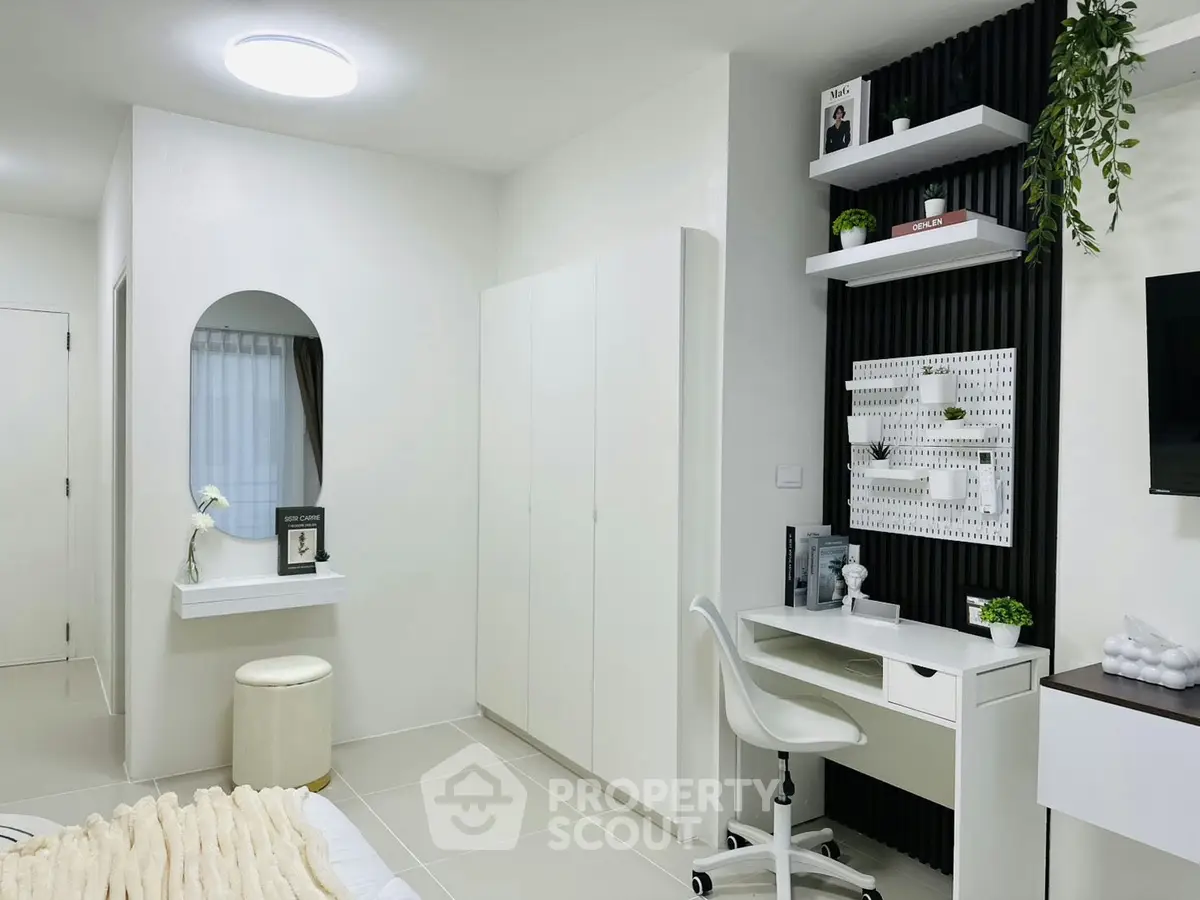 Modern bedroom with sleek white furniture and stylish workspace