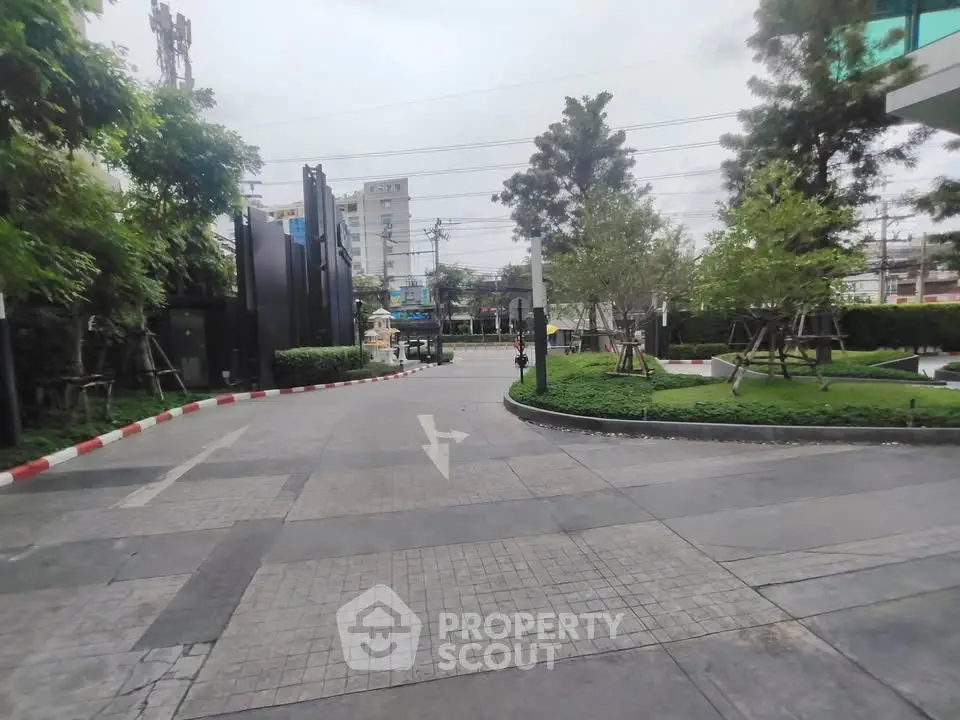 Spacious urban entrance with lush greenery and modern design, ideal for upscale living.