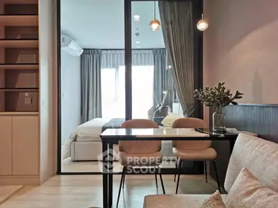 Modern open-plan living room with dining area and view into cozy bedroom.