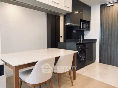 Modern kitchen with sleek appliances and elegant dining area in a stylish apartment.