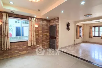 Spacious living room with elegant stone wall accents and large windows for natural light.