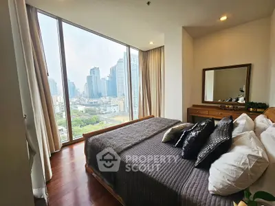 Luxurious bedroom with stunning city view and elegant decor in high-rise apartment.