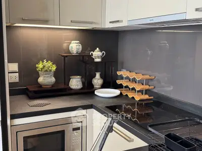 Modern kitchen with sleek appliances and elegant decor, featuring a microwave and electric stove.
