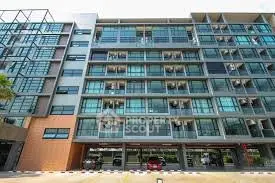 Modern apartment building exterior with large glass windows and parking area